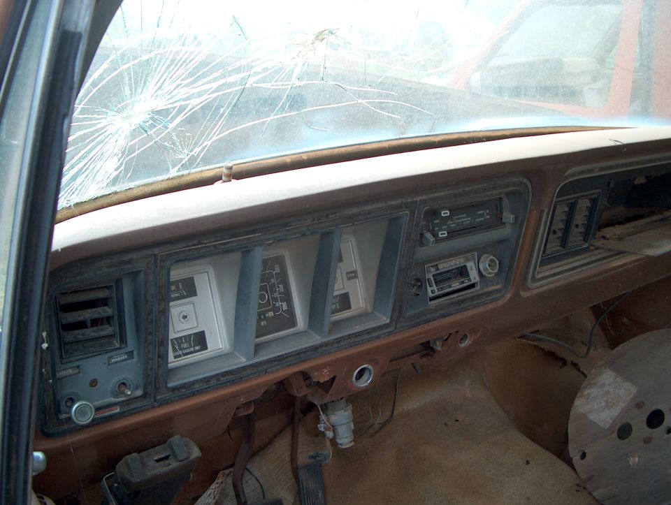1979 Ford Bronco interior dashboard with cracked windshield and aftermarket radio