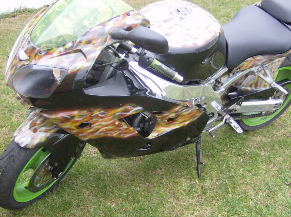 Motorcycle with flame graphics on black and silver bodywork, green rims