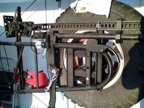 1992 Ford Bronco - A custom spare tire carrier modification is shown, a mounted Hi-Lift jack and a spare tire.