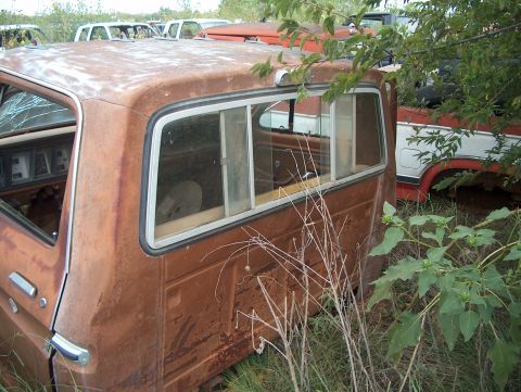 1979 Ford Bronco - This rusty vehicle sits in a junkyard with other abandoned cars.