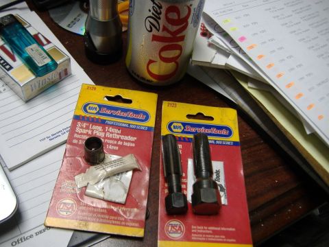 1996 Ford Crown Victoria - A close-up view of automotive tools and a beverage on a cluttered desk surface.