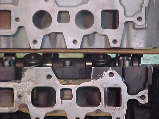 Two cylinder heads compared side by side showing intake port faces and valve springs