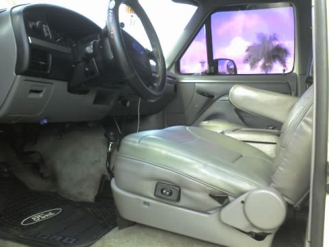 1995 Ford Bronco - The interior of a truck is shown, gray leather seats and a Ford branded floor mat.