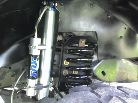 1995 Ford Bronco - Close-up of a Fox shock absorber and coil spring, likely from an off-road vehicle.