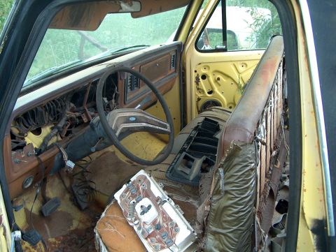 1979 Ford Bronco - The interior of a dilapidated 1979 Ford Bronco shows extensive damage and disrepair.