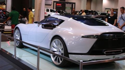 1996 Ford Probe - A futuristic white concept car is showcased at an auto show, a distinctive aerodynamic design and large alloy wheels.