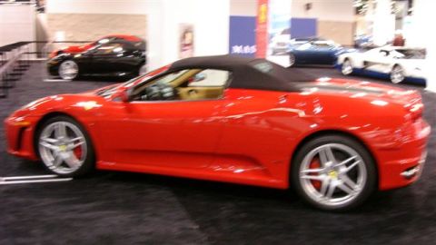 1996 Ford Probe - A red convertible sports car is displayed indoors with other vehicles visible in the background.