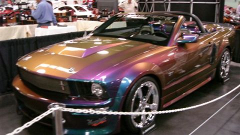1996 Ford Probe - A custom Ford Mustang convertible with a multi-color paint job is displayed indoors.