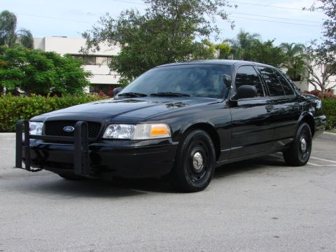 1998 Ford Crown Victoria - A black Ford Crown Victoria police car is shown from a three-quarter front view.