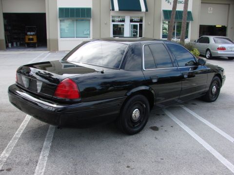 1998 Ford Crown Victoria - Black 1998 Ford Crown Victoria seen from the rear quarter angle with another car in the background.