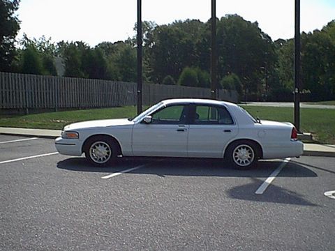 1998 Ford Crown Victoria - Side view of a white 1998 Ford Crown Victoria sedan parked in a lot.