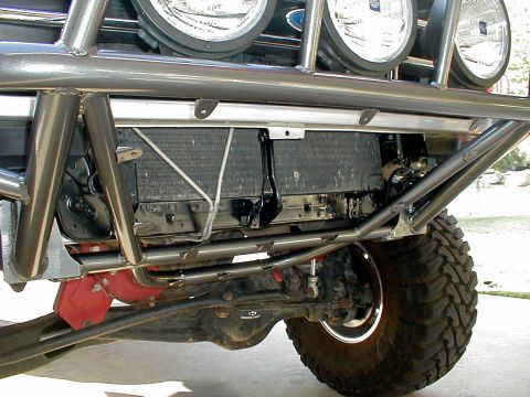 1996 Ford Bronco - Close-up view of the front suspension and custom bumper on an off-road vehicle.