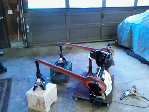 1988 Ford Bronco - Vehicle axle parts are set up on jack stands in a garage with an impact wrench nearby.