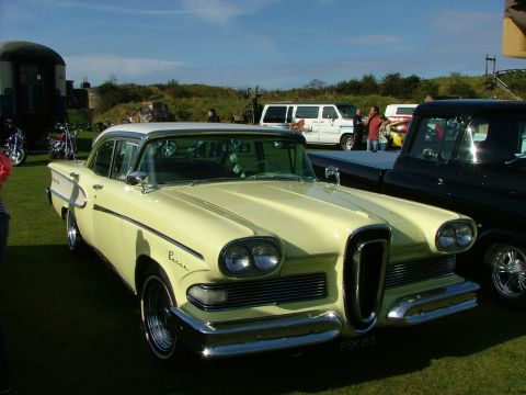 1988 Ford Sport - Yellow 1958 Edsel Pacer sedan with a white roof, parked next to a black pickup truck.