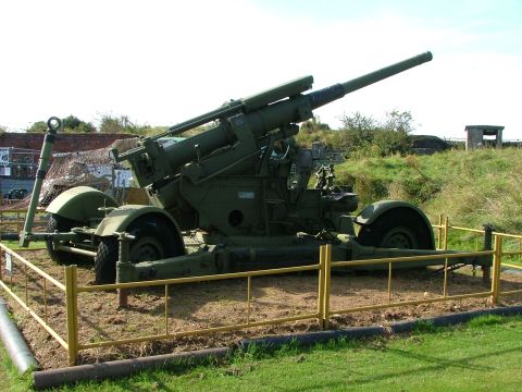 1988 Ford Sport - An anti-aircraft gun is displayed outdoors behind a protective barrier.