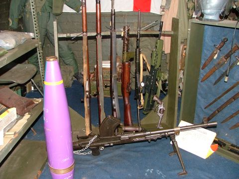 1988 Ford Sport - Display of various firearms and military artifacts, including rifles and a large projectile.
