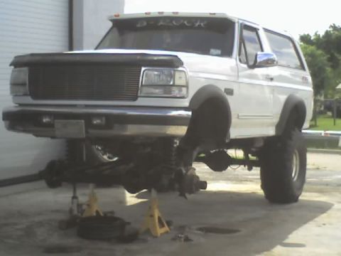 1995 Ford Bronco - White 1995 Ford Bronco is lifted on jack stands for service.