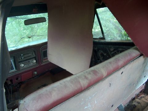 1979 Ford Bronco - The interior of an abandoned vehicle shows signs of wear and tear, with dusty seats and a cracked windshield.
