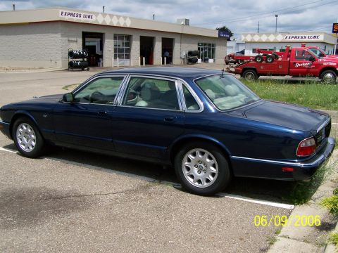 2003 Ford Crown Victoria - A dark blue sedan is parked in a lot outside an Express Lube service center.