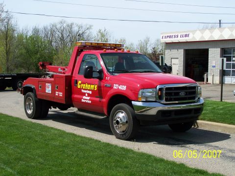 2003 Ford Crown Victoria - A red tow truck is parked in front of a building with 'Express Lube' signage.