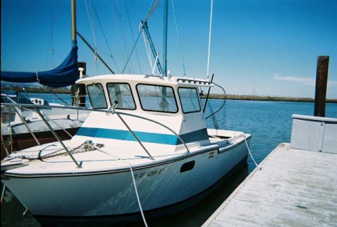 1991 Ford Bronco - A boat is docked at a pier on a sunny day.