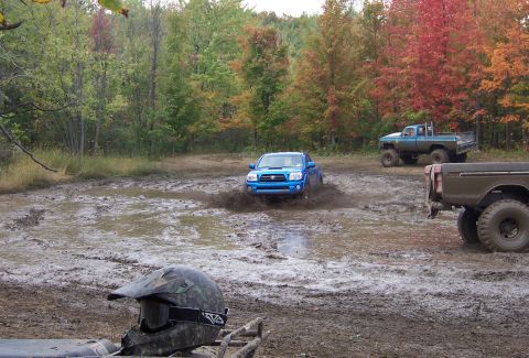 1978 Ford Bronco - Two SUVs and a tent are visible in a muddy outdoor scene.