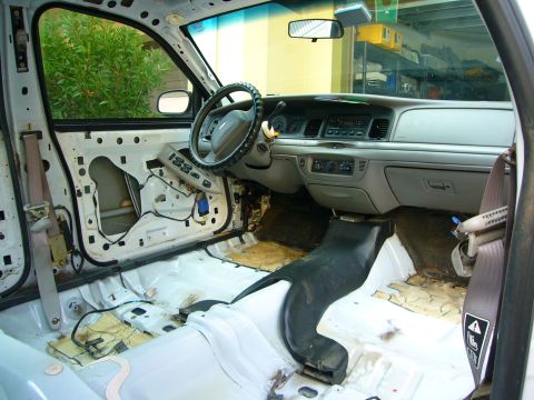 2001 Ford Crown Victoria - The interior of a car is shown with the driver's side door panel removed, revealing the internal components and wiring.