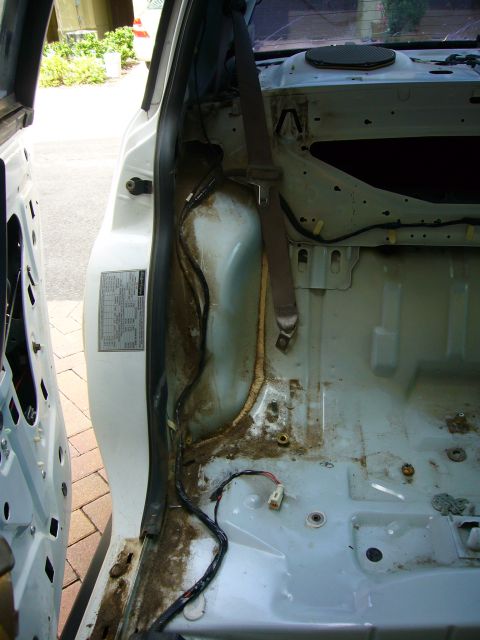 2001 Ford Crown Victoria - The interior of a vehicle is shown with the door open, revealing disassembled components and wiring, suggesting it is in a state of repair…