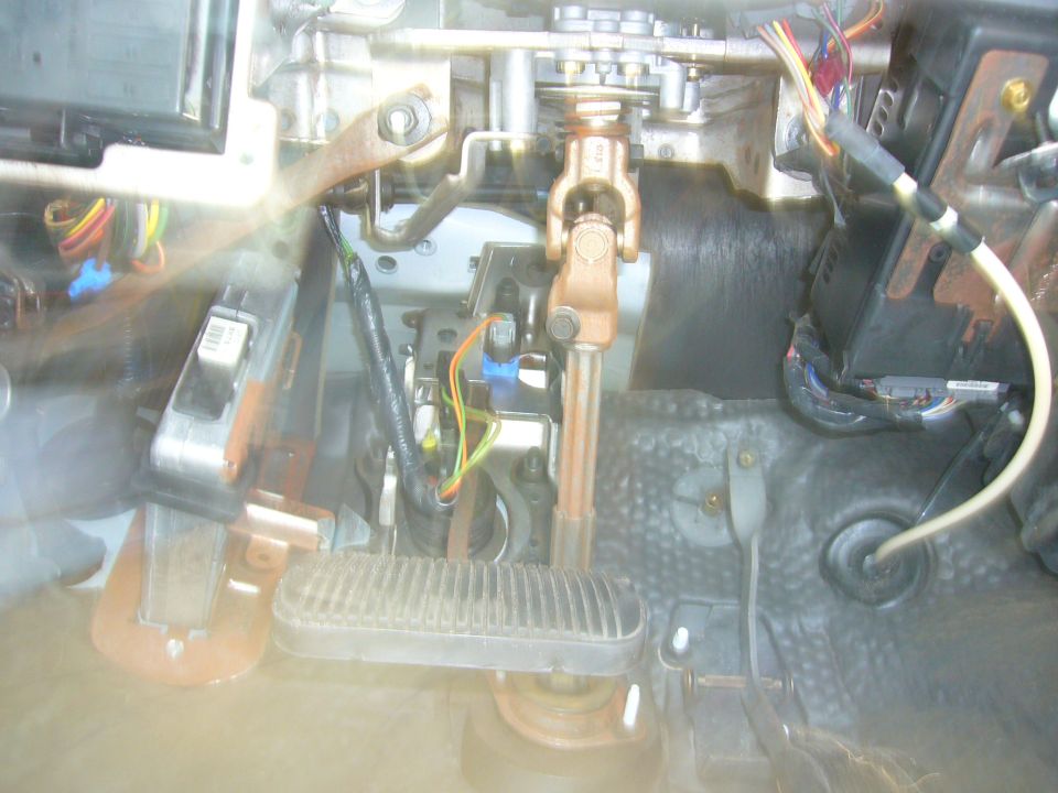 Close-up of steering column and pedals assembly with wiring