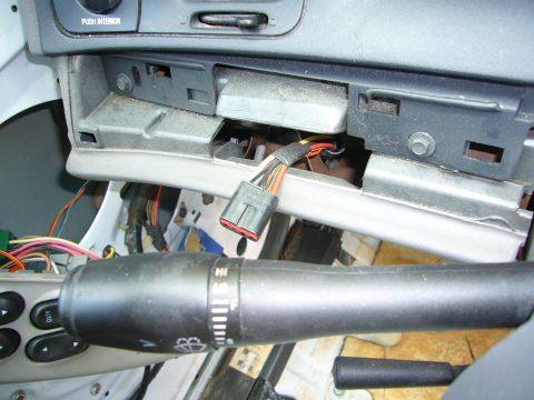 2001 Ford Crown Victoria - The dashboard of a car is disassembled, revealing electrical wiring and components.
