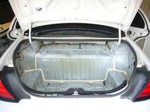 2001 Ford Crown Victoria - The interior of a car's trunk has been stripped bare, revealing the fuel tank and structural components.