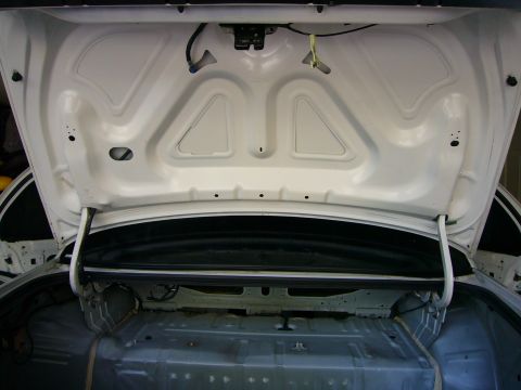 2001 Ford Crown Victoria - The interior of an open car trunk, revealing its bare metal construction and exposed wiring.