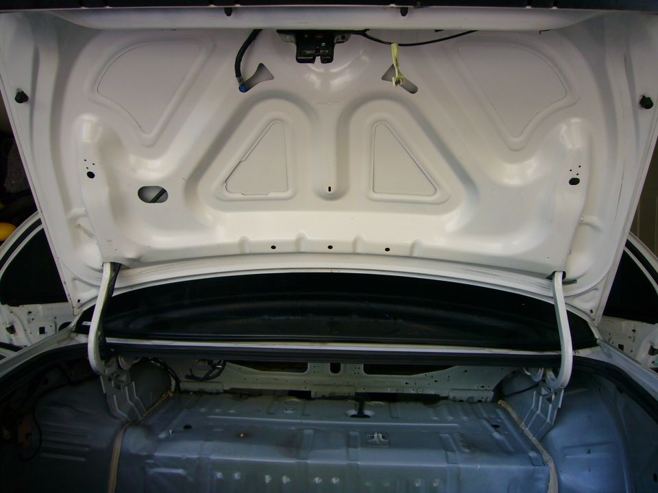 Open white car trunk interior, showing bare metal and wiring, 2001 Ford Crown Victoria