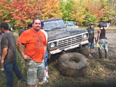 1978 Ford Bronco - Mud bogging event with a 1978 Ford Bronco stuck in the mud. Several people are present.