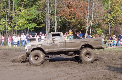 1978 Ford Bronco - This heavily modified Ford F-Series pickup truck navigates a muddy obstacle course with spectators watching.