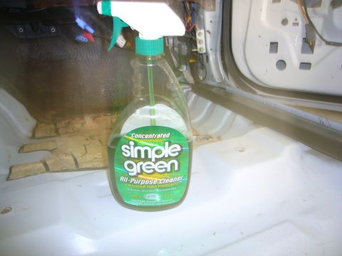 2001 Ford Crown Victoria - A bottle of Simple Green cleaner sits on the floor of a car interior, revealing exposed wiring and a dirty floor.
