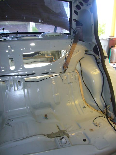 2001 Ford Crown Victoria - The interior of a car has been stripped down, revealing the bare metal frame and wiring harnesses.