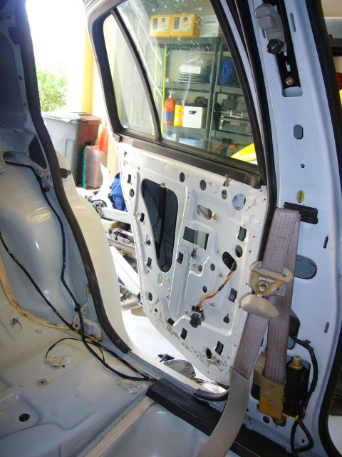 2001 Ford Crown Victoria - The interior of a car is shown with the door panel removed, revealing the inner workings and wiring.