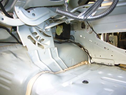 2001 Ford Crown Victoria - The bare interior of a vehicle shows structural components and wiring harnesses after interior trim removal.