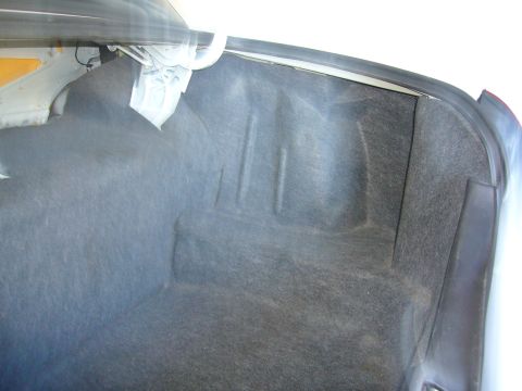 2001 Ford Crown Victoria - The interior of a car trunk is shown, revealing its carpeted surfaces and structural contours.