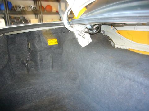 2001 Ford Crown Victoria - The trunk of a 2001 Ford Crown Victoria, showing the carpeted interior and a yellow warning sticker.