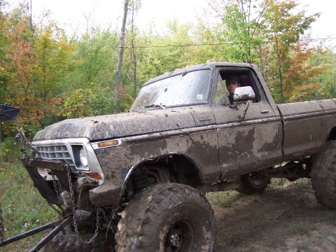 1978 Ford Bronco - This heavily mud-caked pickup truck appears to be navigating an off-road course with large tires and a modified suspension.
