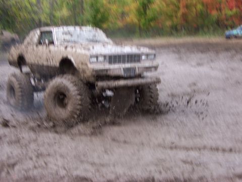 1978 Ford Bronco - Monster truck modified for mud bogging, seen in action with another vehicle in the distance.
