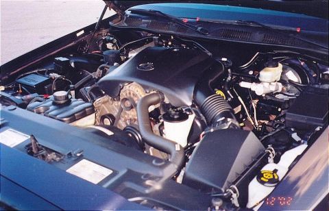 1999 Ford Crown Victoria - The engine bay of a Ford Crown Victoria is shown with the hood raised, revealing the engine components.