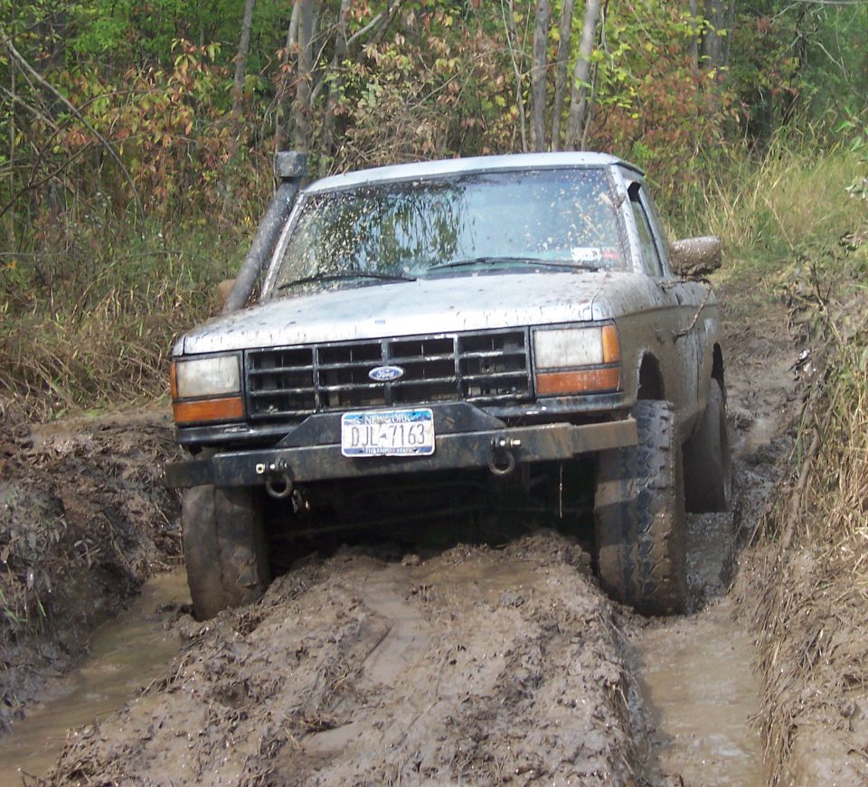 Silver 1990 Ford Ranger stuck in mud with snorkel and aftermarket bumper
