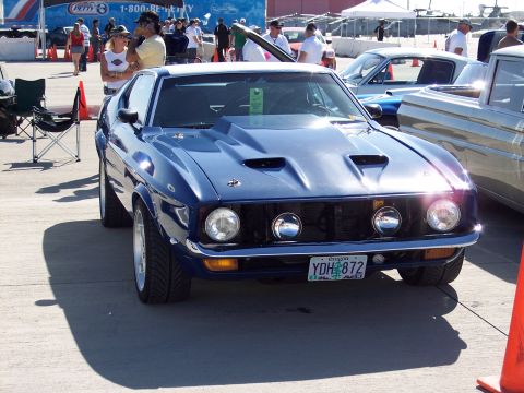 1971 Ford Mustang - A blue coupe with a custom grille and hood scoops is parked outdoors.
