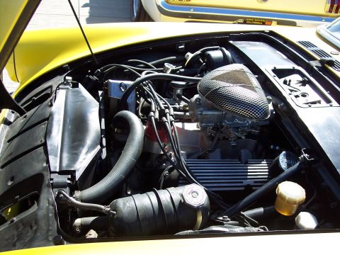 1971 Ford Mustang - Engine bay of a 1971 Ford Mustang, showing the V8 engine and related components. Another vehicle is partially visible.