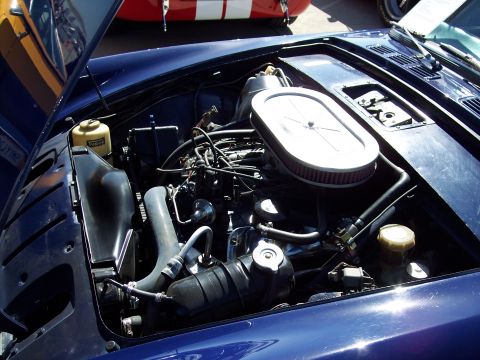 1971 Ford Mustang - Close-up view of a blue car's engine bay, showing the air filter, hoses, and a yellow fluid reservoir.