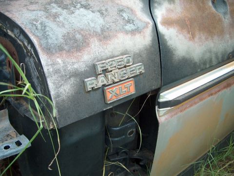 1979 Ford Bronco - Close-up of the F250 RANGER XLT badging on a weathered vehicle.