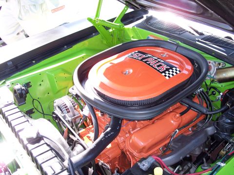 1971 Ford Mustang - Close-up of a vehicle's engine bay, highlighting an orange air cleaner assembly with "SIX PACK" branding.